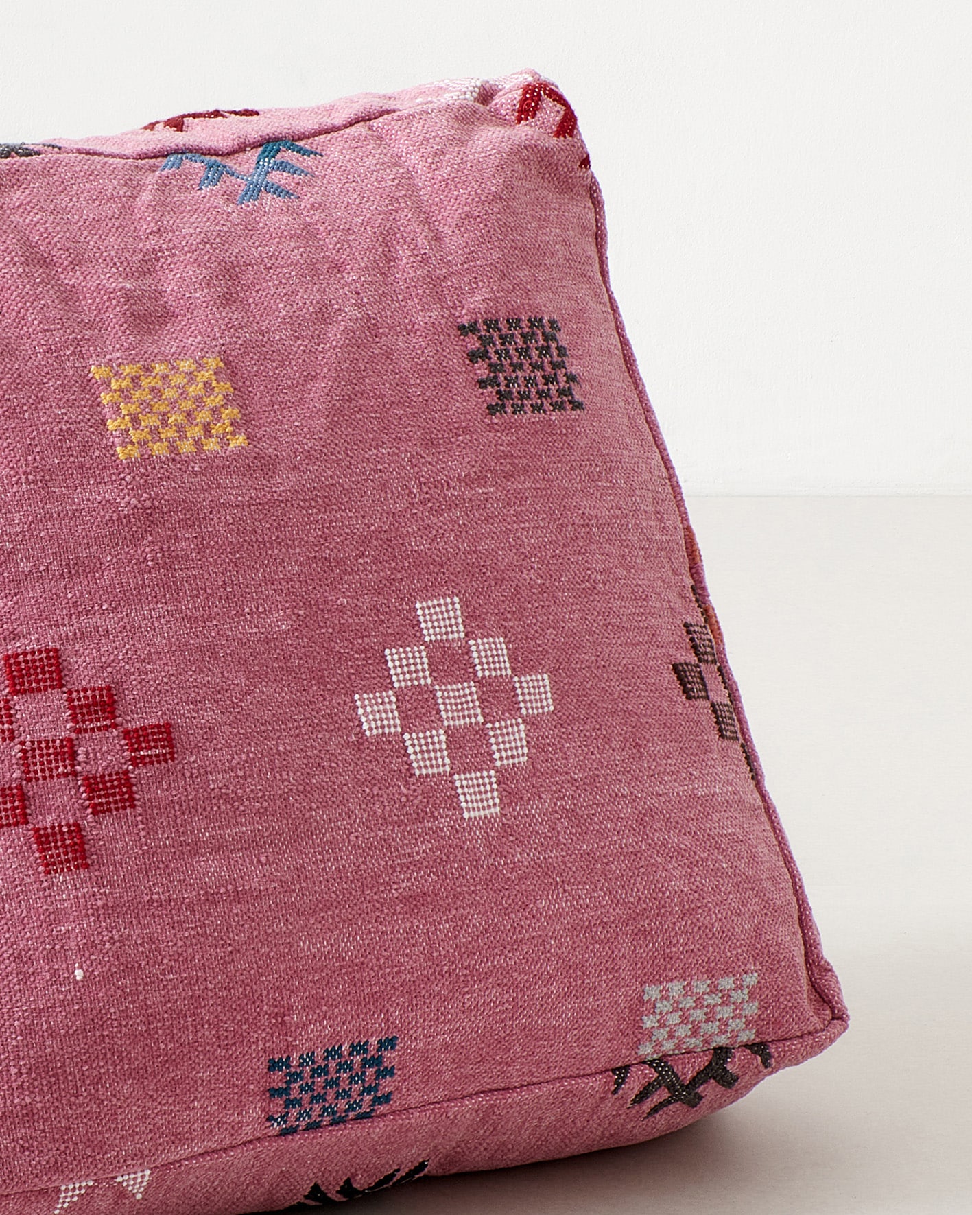 Pink pouf with colourful pictograms, close