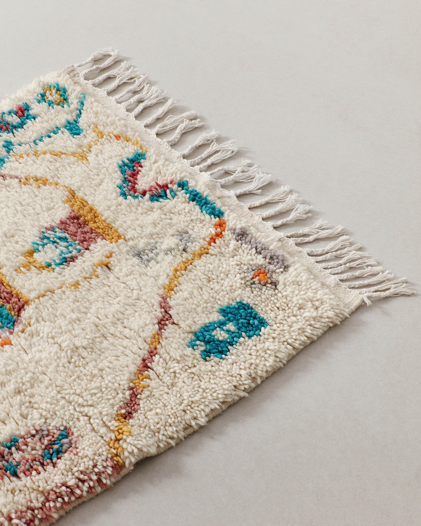 Tiny rug with turquoise motifs, fringe