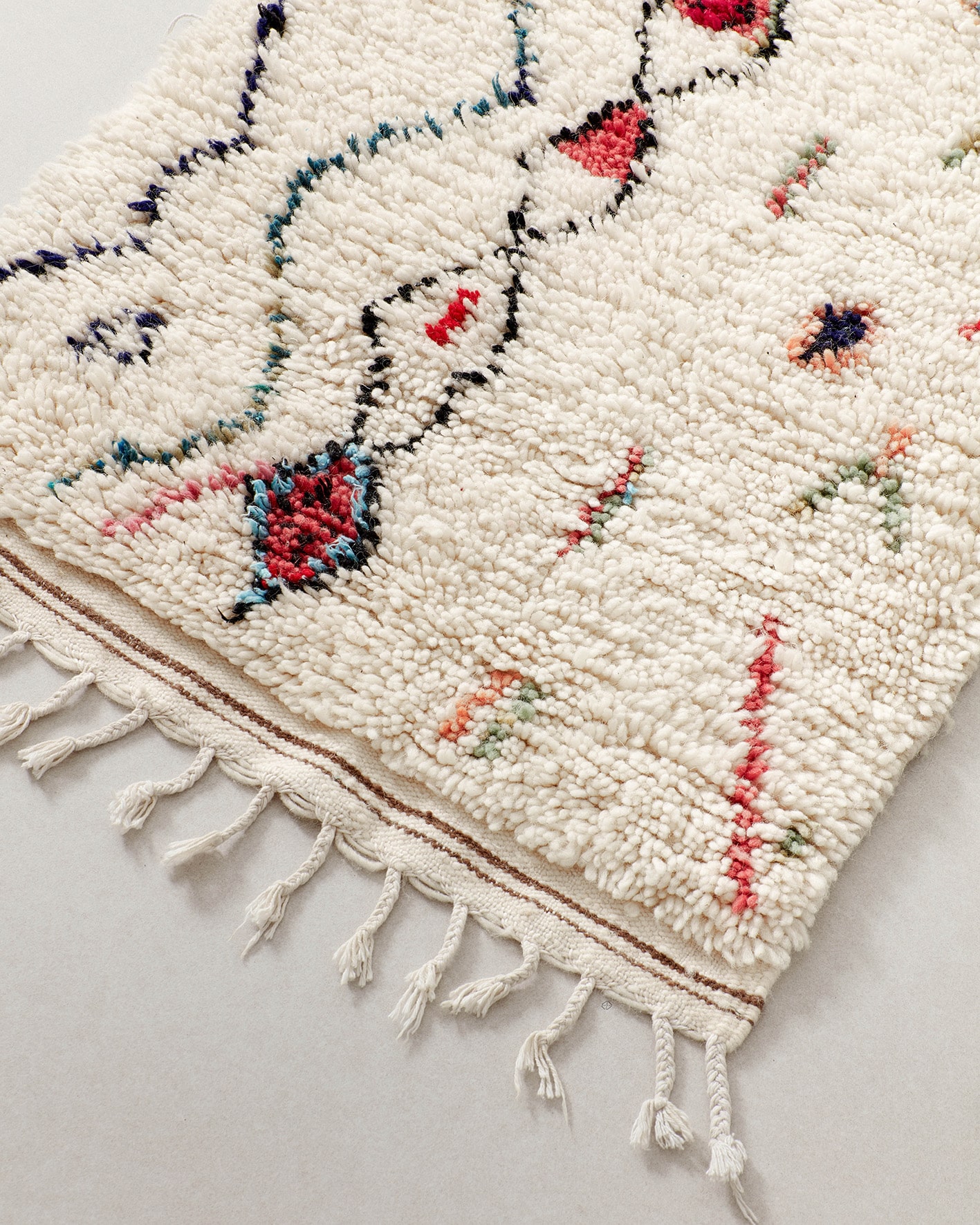 Tiny rug with abstract line drawings, fringe