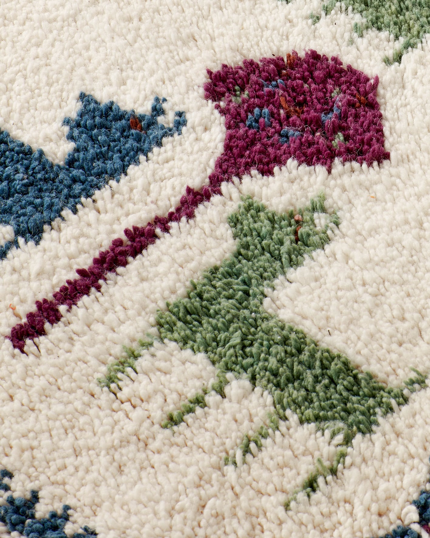 Tiny rug featuring animals in blue-green-burgundy colours, texture